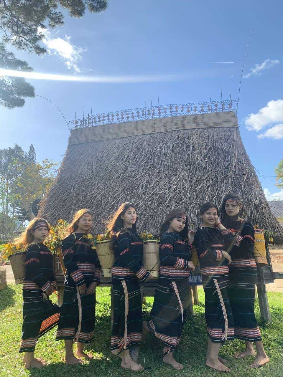 Các thiếu nữ dân tộc Gia Rai bên mái nhà Rông. 