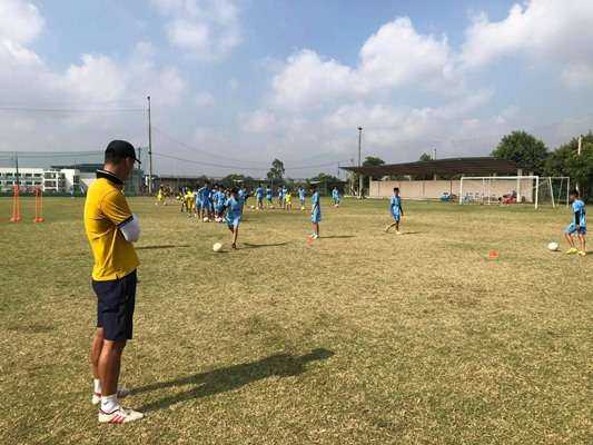 HLV CLB Hải Nam hướng dẫn kĩ năng chơi bóng đá cho các cầu thủ.