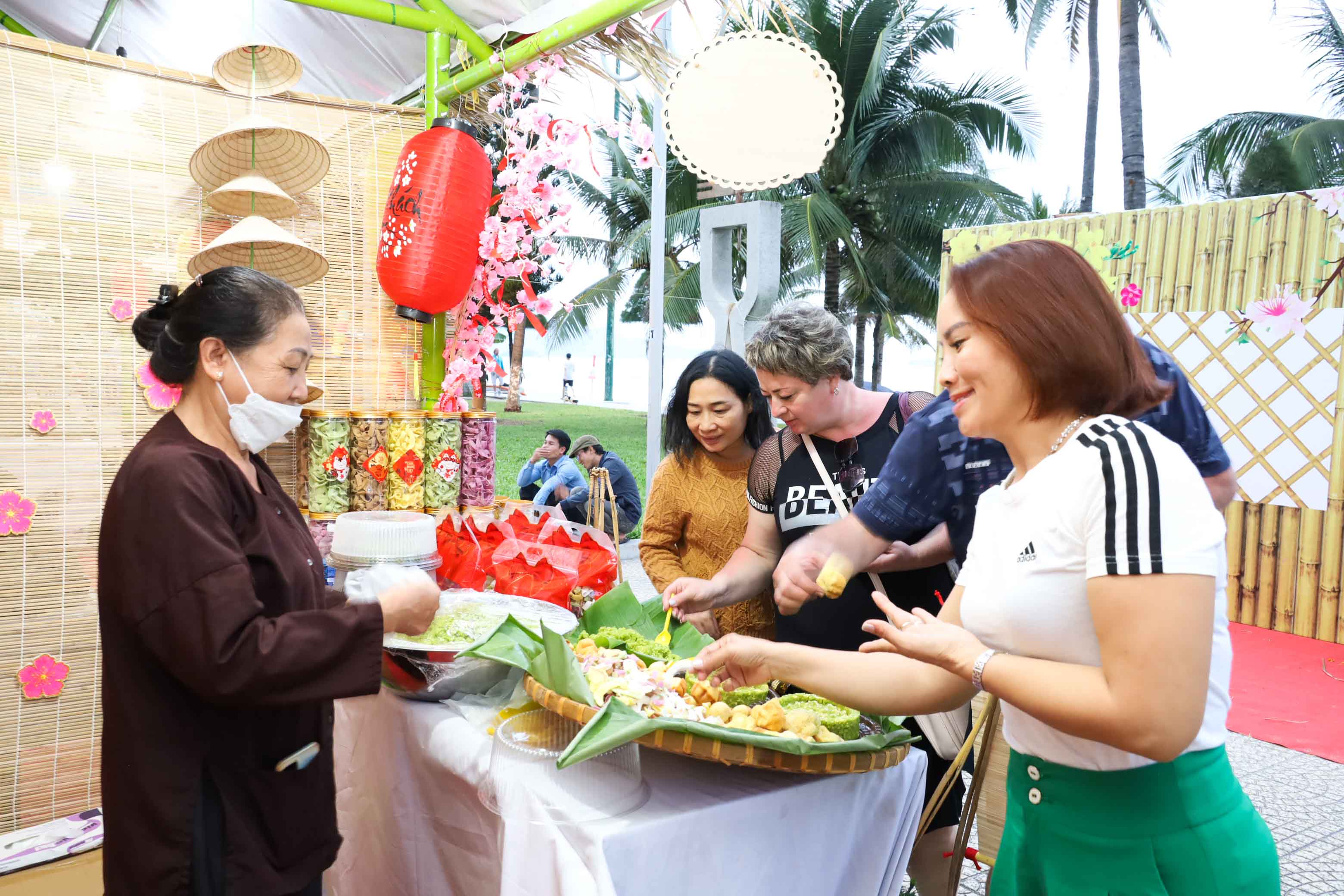 Gian hàng bánh truyền thống của nghệ nhân Lê Thị Điểu (huyện Cam Lâm) thu hút khách đến tham quan, thưởng thức. 
