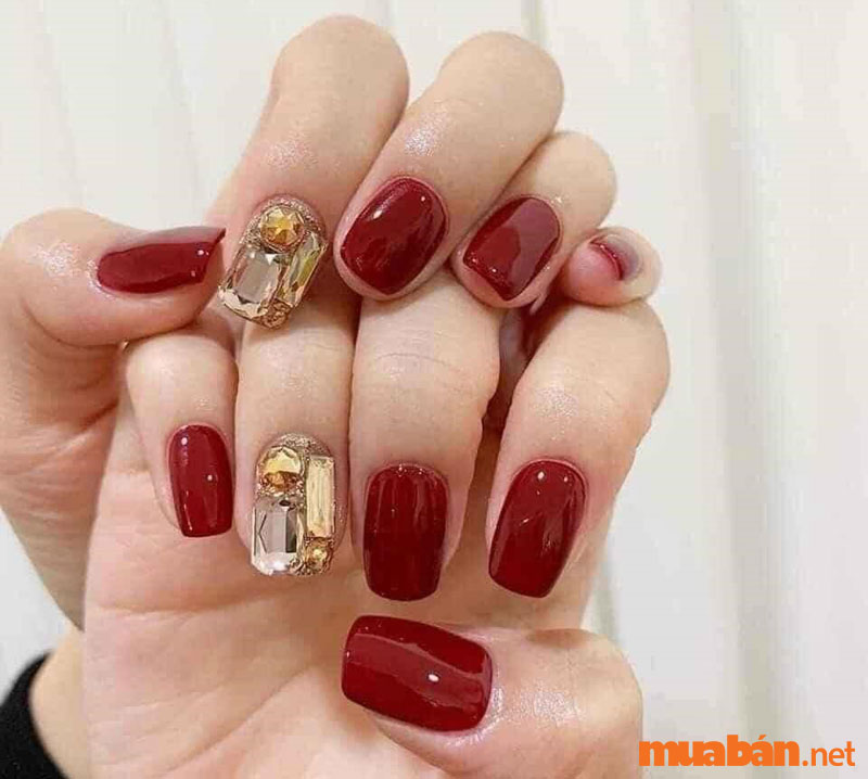 Mẫu nail Tết 2023 với sơn đỏ đô mạnh mẽ và đá bản to