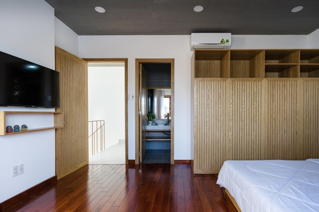 Không gian phòng ngủ ấm cúng với nền nhà ốp gỗ màu cánh dán. 