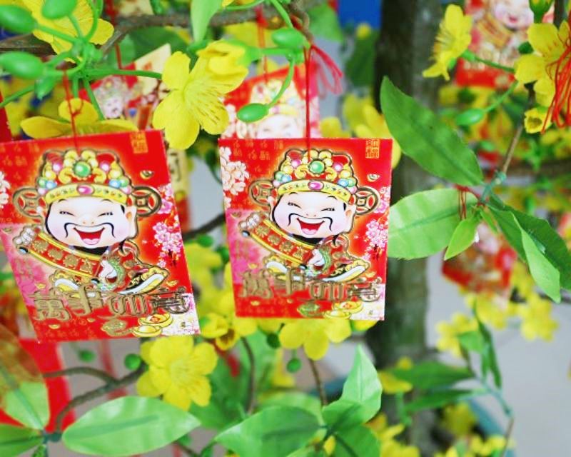 Trang trí cây mai ngày Tết bằng bao lì xì đỏ may mắn